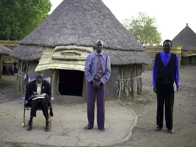 Men wait for Sunday mass near a church at a village in a rebel-controlled territory in Upper Nile State, South Sudan, February 9, 2014. (Photo by Goran Tomasevic/Reuters)