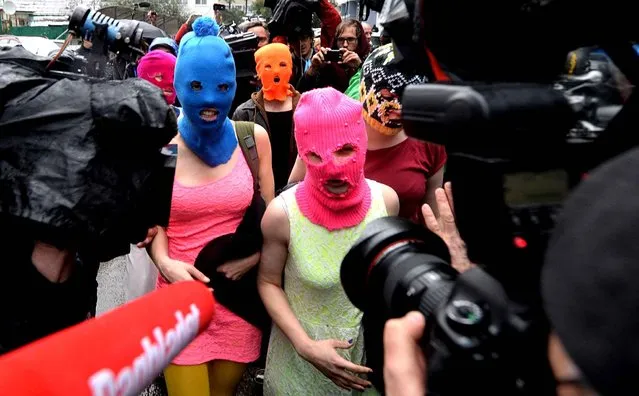 Wearing masks members of Russian punk group p*ssy Riot, Nadezhda Tolokonnikova (L) and Maria Alyokhina (R) speak to journalists while leaving the police station of Adler, near Sochi, on February 18, 2014 after her arrest earlier in the host city of the 2014 Winter Olympics. Tolokonnikova and Maria Alyokhina walked free after being questioned about an alleged theft from a hotel. (Photo by Andrej Isakovic/AFP Photo)