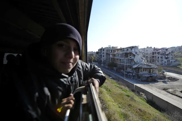 A boy rides a train as damaged buildings are pictured in the background in Aleppo, Syria February 1, 2017. (Photo by Omar Sanadiki/Reuters)