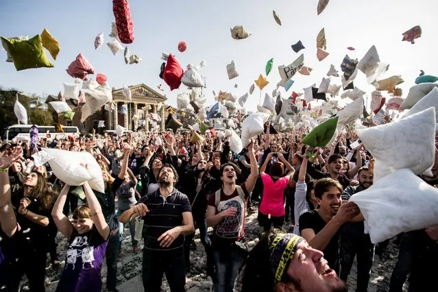 Young people throw pillows into the air as they mark International Pillow Fight Day in the Heroes' Square, in central Budapest, Hungary, Saturday, April 2, 2016. (Photo by Zoltan Balogh/MTI via AP Photo)