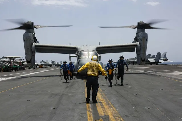 In this Friday, May 17, 2019, photo, released by the U.S. Navy, sailors work around an MV-22 Osprey as it lands on the flight deck of the Nimitz-class aircraft carrier USS Abraham Lincoln in the Arabian Sea. Commercial airliners flying over the Persian Gulf risk being targeted by “miscalculation or misidentification” from the Iranian military amid heightened tensions between the Islamic Republic and the U.S., American diplomats warned Saturday, May 18, 2019, even as both Washington and Tehran say they don't seek war. (Photo by Mass Communication Specialist 3rd Class Amber Smalley/U.S. Navy via AP Photo)