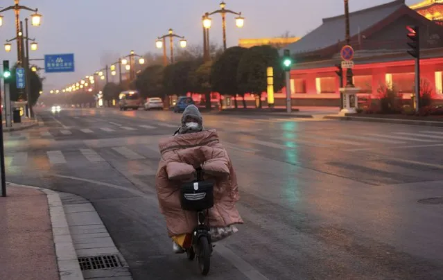 A citizen rides in an almost-empty street in Xian city in Shaanxi province Thursday, January 06, 2022. The city of 13 million people reported 63 Covid-19 cases on Wednesday, showing a downward trend after two weeks into lockdown. (Photo by Roy Stone/Future Publishing via Getty Images)