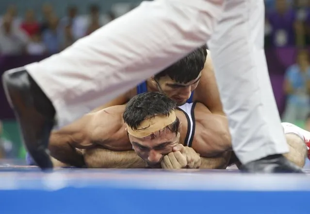 Roman Amoyan of Armenia, bottom, and Elman Mukhtarov of Azerbaijan compete in the the Men's wrestling, 59kg Greco-Roman Bronze Medal event at the 2015 European Games in Baku, Azerbaijan, Saturday, June 13, 2015. (AP Photo/Dmitry Lovetsky)