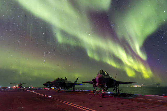 In this photo provided by Britain's Ministry of Defense, on Monday, March 4, 2024, F-35B Lightning jets are parked at a flight deck of HMS Prince of Wales aircraft carrier of the Royal Navy, under the northern lights (Aurora Borealis) near the coast of Norway, Sunday, March 3, 2024. (Photo by UK Ministry of Defence via AP Photo)