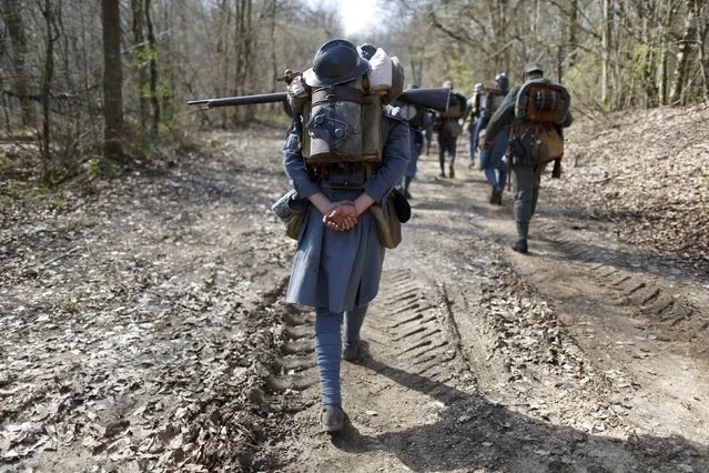 French (in blue) and German members of World War One historical associations take part in a 15-km (9-mile) walk through the national forest of Verdun, eastern France, March 29, 2014. (Photo by Charles Platiau/Reuters)