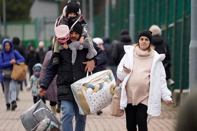 A family exits the border after crossing over to flee violence in Ukraine, in Medyka, Poland on February 25, 2022. (Photo by Bryan Woolston/Reuters)