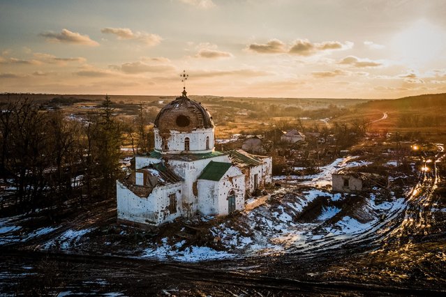 This aerial photograph shows a damaged church, which was used by Russian troops as a makeshift hospital, in the village of Mala Komyshuvakha, Kharkiv region, on February 22, 2023, amid Russia's military invasion on Ukraine. (Photo by Ihor Tkachov/AFP Photo)