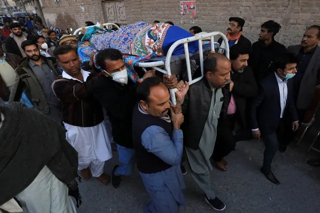 Men carry the body of priest William Siraj, who, according to police, was killed by unknown armed men in Peshawar, Pakistan on January 30, 2022. (Photo by Fayaz Aziz/Reuters)