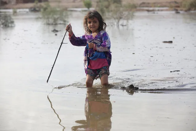 A girl plays in floodwater at a camp for internally displaced people in the Dhanah area of the central province of Marib, Yemen, April 30, 2016. (Photo by Ali Owidha/Reuters)