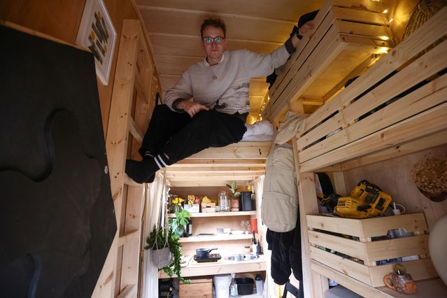 Artist Harrison Marshall poses inside the skip which he has converted into a home, where he intends to live in for a year, in Bermondsey, London, Britain on March 3, 2023. (Photo by Henry Nicholls/Reuters)