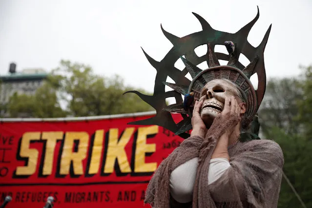 A woman wearing a costume stands during a May Day protest in New York, U.S. May 1, 2017. (Photo by Mike Segar/Reuters)