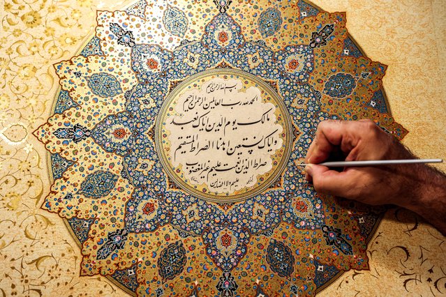 Mohammad Hossein Aghamiri, an artist who specialises in Persian miniatures, works on one of his pieces depicting al-Fatiha, the first chapter of the Koran (Islam's holy book), at his workshop in Tehran on June 5, 2024. (Photo by Atta Kenare/AFP Photo)