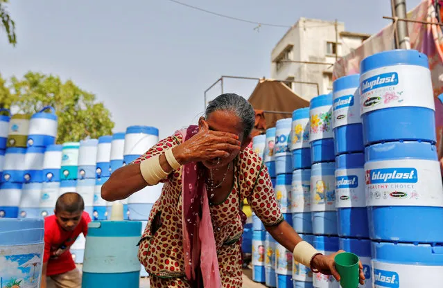 A woman splashes water on her face to cool down at a public water station in Ahmedabad, India May 20, 2016. (Photo by Amit Dave/Reuters)