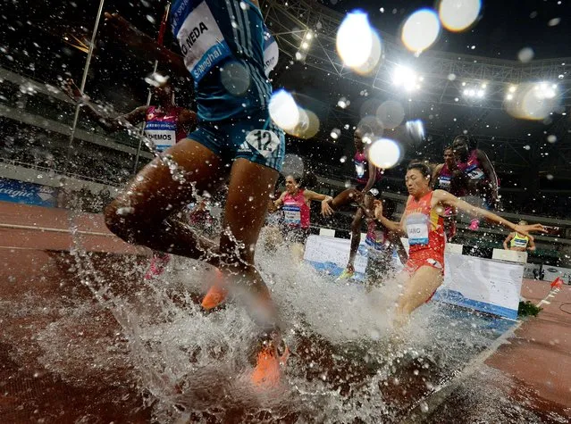 Runners compete in the women's 3000m steeplechase event at the Diamond League athletics meeting in Shanghai on May 18, 2014. (Photo by Mark Ralston/AFP Photo)