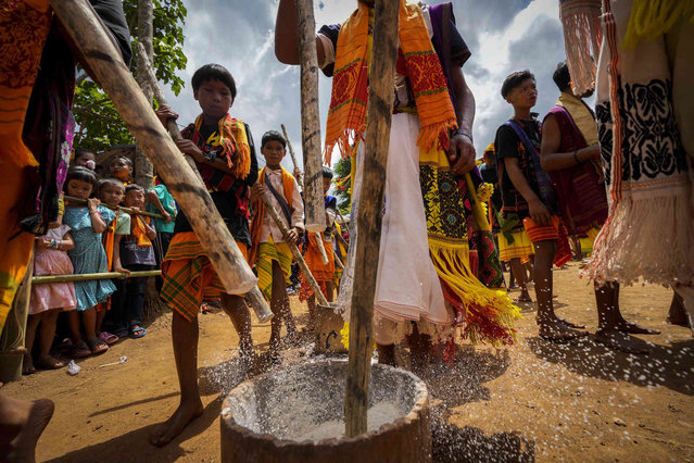 Tiwa tribal men in their traditional attire pound rice during Wanchuwa festival in a village in Karbi Angling district, India, Wednesday, July 24, 2024. Wanchuwa festival, marked once every five years, is celebrated for a good harvest and the welfare of the people. (Photo by Anupam Nath/AP Photo)