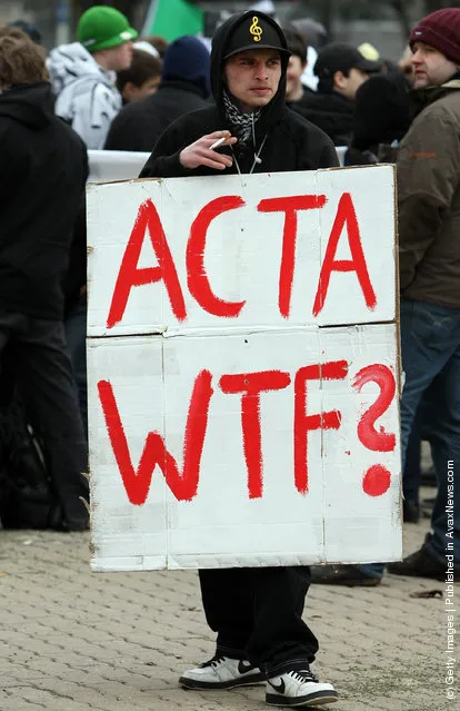 Activists protest from inside the Neptune fountain at Alexanderplatz during a demonstration against the Anti-Counterfeiting Trade Agreement (ACTA)