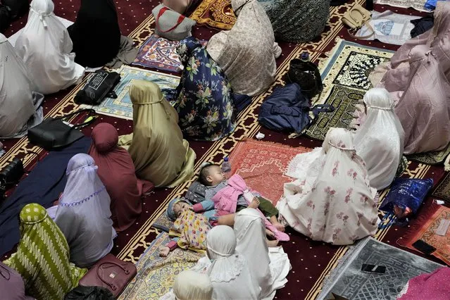 Children sleep as Muslim women perform an evening prayer called “tarawih” that marks the first eve of the holy fasting month of Ramadan at Istiqlal Mosque in Jakarta, Indonesia, Saturday, April 2, 2022. During Ramadan Muslims refrain from eating, drinking, smoking and s*x from dawn to dusk. (Photo by Dita Alangkara/AP Photo)