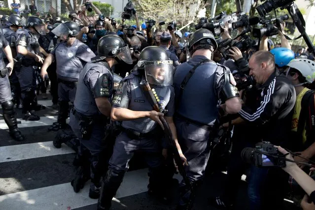 Police shouts at journalists covering the detention of a protestor in Sao Paulo, Brazil, Thursday, June 12, 2014. (Photo by Rodrigo Abd/AP Photo)