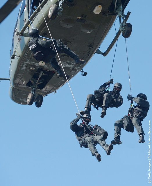 Members of Germany's elite police unit, the Spezialeinsatzkommando, or SEK, demonstrate an abseil deployment from a helicopter during a media event