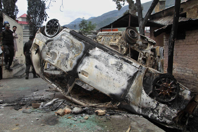 Police officers examine burnt vehicles which were torched by a Muslim mob in an attack, in Madyan in Pakistan's Khyber Pakhtunkhwa province, Friday, June 21, 2024. A Muslim mob in northwestern Pakistan broke into a police station, snatched a man who was held there and then lynched him over allegations that he had desecrated Islam's holy book, the Quran. (Photo by Naveed Ali/AP Photo)