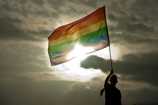 A person holds a rainbow flag during the Gay Pride Parade in San Salvador, El Salvador, on June 28, 2014. (Photo by Jose Cabezas/AFP Photo)