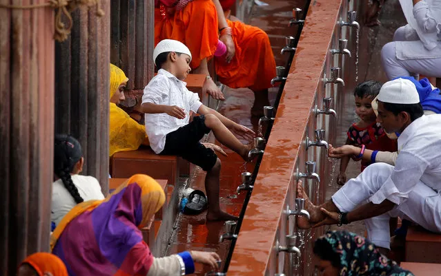 A Muslim boy performs ablution before offering prayers during Jumat-ul-Vida, or the last Friday of the holy fasting month of Ramadan, inside Jama Masjid (Grand Mosque) in the old quarters of Delhi, India, June 23, 2017. (Photo by Cathal McNaughton/Reuters)