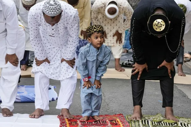 A Muslim boy offers prayers with elders on Eid al-fitr in Kolkata, India, Tuesday, May 3, 2022. Muslims make 14 percent of India's 1.4 billion population and are the largest minority group in the Hindu-majority nation. (Photo by Bikas Das/AP Photo)