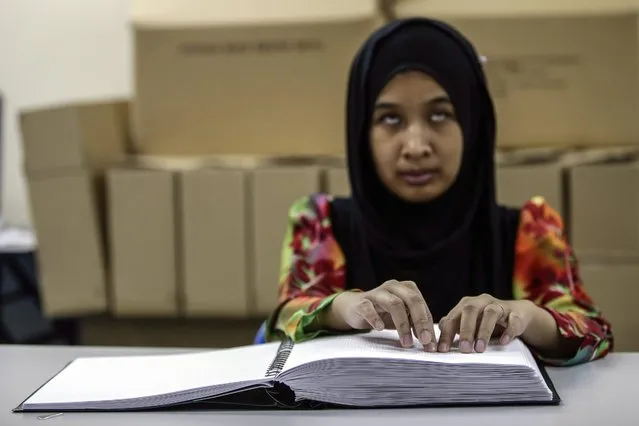 Siti Haida Hamidan, 30, blind Malaysian recite the Koran in Braille writing system at the Malaysia Muslim Association of Visually Impaired People center (PERTIM) during Ramadan in Kuala Lumpur, Malaysia, 24 June 2016. PERTIM was established on 1996 is the only NGO that obtained a permission from the Malaysia goverment for copyright and printing of Koran in Braille. Koran in Braille must be read from left to right through the six volumes that span the entire paragraph Koran. (Photo by Fazry Ismail/EPA)