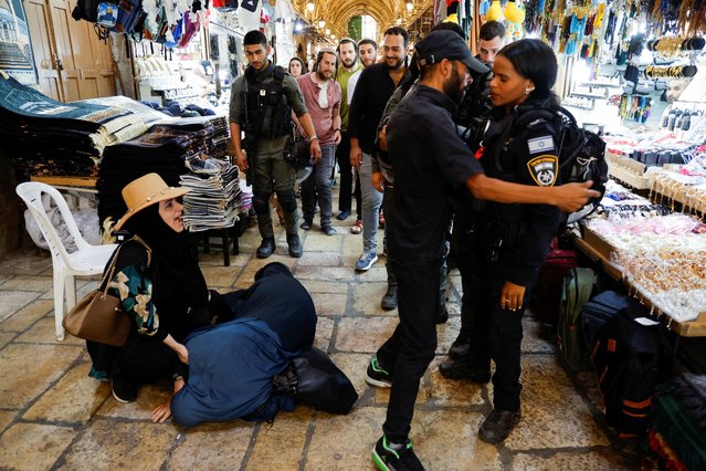 A woman lies on the ground as Israeli police blockade the entrance to Al-Aqsa compound also known to Jews as Temple Mount, following a visit to the site by Israel's hard-right National Security Minister Itamar Ben-Gvir, in Jerusalem's Old City on July 27, 2023. (Photo by Ammar Awad/Reuters)