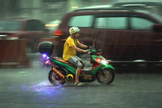 A picture taken with a slow shutter speed shows a motorist navigating a road during a downpour in Manila, Philippines, 04 July 2016. The Philippine Astronomical Geophysical Services Administration (PAGASA) state weather bureau announced on 04 July that Tropical storm Nepartak was estimated to be located at 1,995 km east of the Visayas islands, with maximum sustained winds of 65 kilometers per hour near the center, with wind gusts of up to 80 kilometers per hour. The PAGASA warned residents living in mountainous areas of possible landslides and floods on low lying areas. (Photo by Mark R. Cristino/EPA)