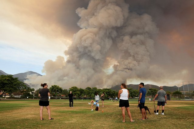 People look on, as the Airport Fire burns in the hills of Orange County, California on September 9, 2024. (Photo by Mike Blake/Reuters)