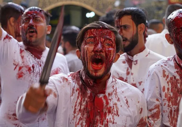 Shiite Muslims take part in the “Tatbir” bloodletting ritual as an act of mourning marking Ashura, a 10-day period commemorating the seventh century killing of Prophet Mohammed's grandson Imam Hussein, in Iraq's central holy city of Najaf, early on August 9, 2022. (Photo by Ali Najafi/AFP Photo)