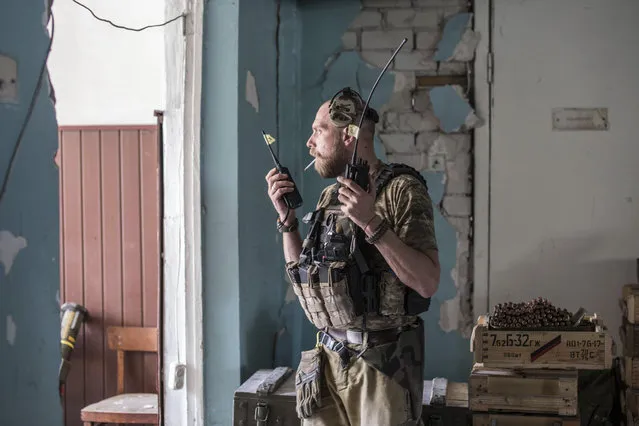 A Ukrainian soldier holds radios during heavy fighting on the front line in Severodonetsk, the Luhansk region, Ukraine, Wednesday, June 8, 2022. (Photo by Oleksandr Ratushniak/AP Photo)