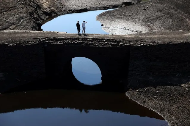 People look at the low water levels at Baitings Reservoir in Ripponden, West Yorkshire, Britain on August 10, 2022. (Photo by Lee Smith/Reuters)
