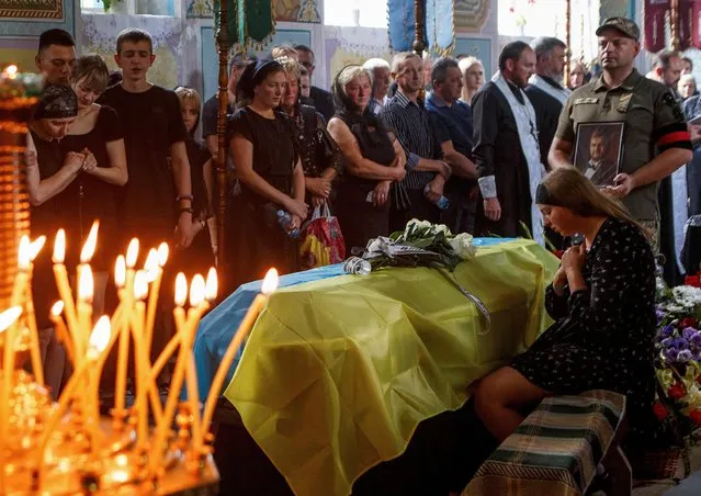 Viktoriia reacts next to a coffin with the body of her husband Vitalii Holubka, Ukrainian serviceman who was recently killed in a fight with Russian troops, amid Russia's attack on Ukraine, during a funeral ceremony in the town of Chop, Zakarpattia region, Ukraine on August 17, 2022. (Photo by Serhii Hudak/Reuters)