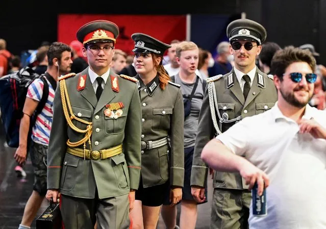 Three people wearing NVA-uniforms of the former German Democratic Republic attend the Gamescom 2022 in Cologne, Germany on August 25, 2022. (Photo by Benjamin Westhoff/Reuters)
