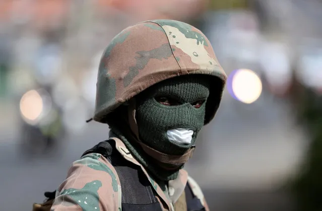 A member of the South African National Defence Force looks on during a patrol in an attempt to enforce a 21 day nationwide lockdown, aimed at limiting the spread of coronavirus disease (COVID-19), in Alexandra township, South Africa, March 28, 2020. (Photo by Siphiwe Sibeko/Reuters)