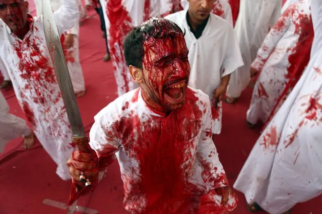 Iraqi Shiite Muslims take part in a traditional mourning event during Ashura commemorations that mark the killing of Imam Hussein, one of Shiite Islam's most revered figures, early October 1, 2017 in the holy city of Najaf. Ashura, commemorates the killing of Imam Hussein, the grandson of the Prophet Mohammed, by the army of the Caliph Yazid in 680 AD, the formative event in Shiite Islam. (Photo by Haidar Hamdani/AFP Photo)