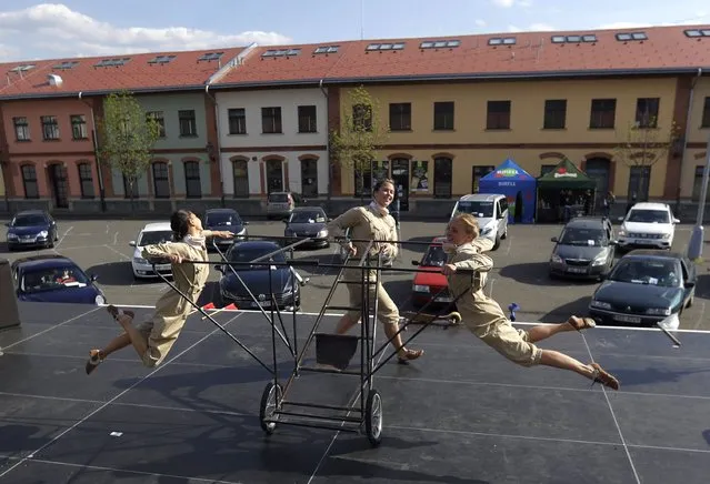 Artists perform as people watch from the safety of their cars, during the Art Parking drive-in festival in Prague, Czech Republic, Sunday, April 26, 2020. Artists in Czech Republic are finding different ways to perform as regular theaters remain closed in an effort to stem the spread of coronavirus. (Photo by Petr David Josek/AP Photo)