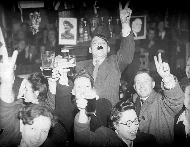 A győzelem napjának ünneplése 1945. május 8-án Londonban, Lambethben, amikor az ember öltözködik Hitlerként egy söröző pubban.  (Fotó: Trinity Mirror / Mirrorpix / Alamy Stock fotó)