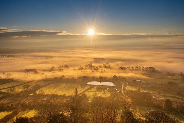 The view from Glastonbury Tor looking over the Somerset Levels, UK, “a misty paradise” as the December sun rose, in the words of the photographer. (Photo by Michelle Cowbourne/South West News Service)