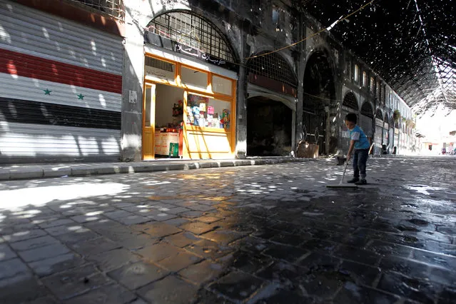 A boy cleans the floor at the government-controlled historical old souk of Homs, Syria July 19, 2016. Picture taken July 19, 2016. (Photo by Omar Sanadiki/Reuters)
