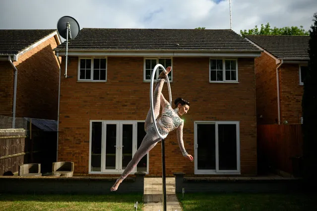 Katia McGurk, and aerial and fire performer, practices her aerial hoop act in the garden of her home in Daventry, central England on May 23, 2020, during the novel coronavirus COVID-19 pandemic. Following training at various circus schools, Katia McGurk began performing her aerial and fire skills in 2011. Her clients include: television, weddings, corporate functions and shows on cruise ships – all of which have been affected by the coronavirus pandemic. (Photo by Oli Scarff/AFP Photo)