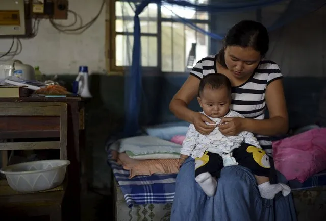 Lu Xiaofang, a 34-year-old college graduate who is the founder and a teacher of Dalu primary school, dresses her 9-month-old son, at her home near the school in Gucheng township of Hefei, Anhui province, China, September 8, 2015. (Photo by Reuters/Stringer)