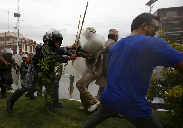 Nepalese riot police personnel clash with Hindu activists trying to break through a restricted area near the parliament during a protest rally demanding Nepal to be declared as a Hindu state in the new constitution, in Kathmandu, Nepal September 14, 2015. (Photo by Navesh Chitrakar/Reuters)