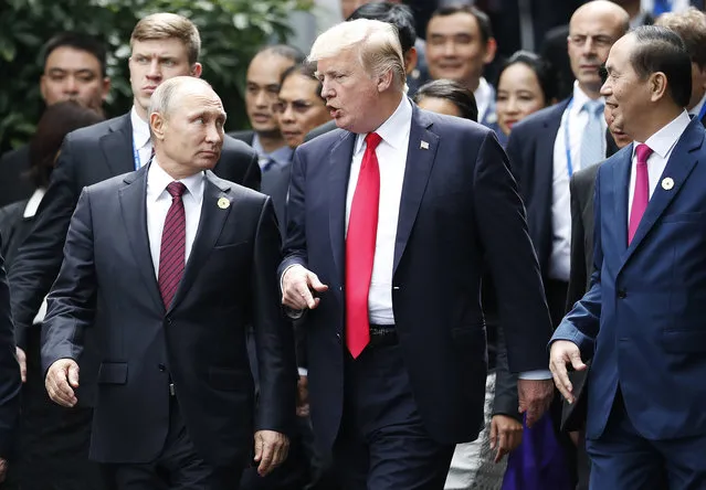 U.S. President Donald Trump and Russia's President Vladimir Putin talk as Vietnam's President Tran Dai Quan, right, looks on during the family photo session at the APEC Summit in Danang, Vietnam, Saturday, November 11, 2017. (Photo by Jorge Silva/Pool Photo via AP Photo)