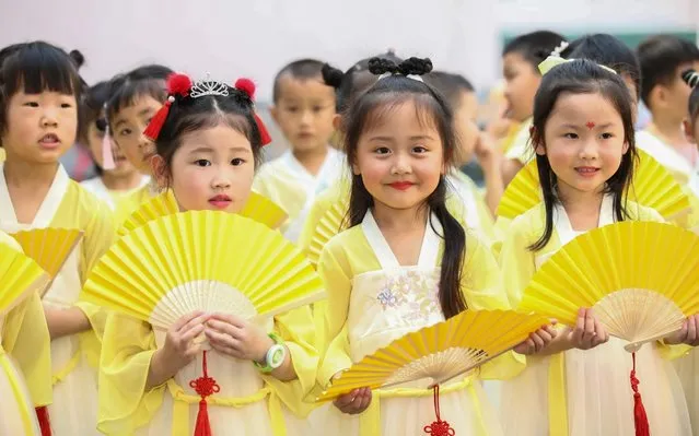 Dressed in ancient Chinese clothes, children at a local kindergarten dance and make traditional perfumed medicine bag to celebrate the upcoming Dragon Boat Festival, Ganyu district, Lianyungang city, east China's Jiangsu province, 19 June 2020. (Photo by Imaginechina via AP Images)