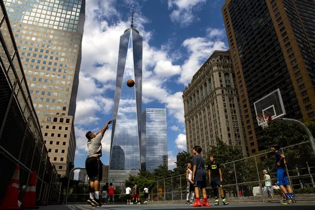 One World Trade Center towers over lower Manhattan as children play basketball in New York August 26, 2015. (Photo by Brendan McDermid/Reuters)