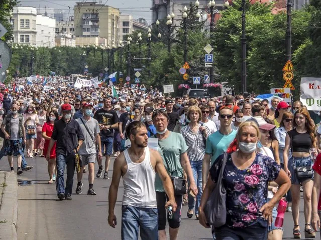 People march during a protest in support of Sergei Furgal, the governor of the Khabarovsk region, in Khabarovsk, 6100 kilometers (3800 miles) east of Moscow, Russia, Saturday, July 18, 2020. Tens of thousands of people in the Russian Far East city of Khabarovsk took to the streets on Saturday, protesting the arrest of the region's governor on charges of involvement in multiple murders. Local media estimated the rally in the city attracted from 15,000 to 50,000 people. (Photo by Igor Volkov/AP Photo)