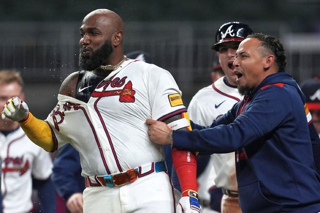 Atlanta Braves designated hitter Marcell Ozuna (20) celebrates with the team after he hit a walk-off two-run homer against the Philadelphia Phillies in the 11th inning of a baseball game after a rain delay, Friday, April 11, 2025, in Atlanta. (Photo by Mike Stewart/AP Photo)